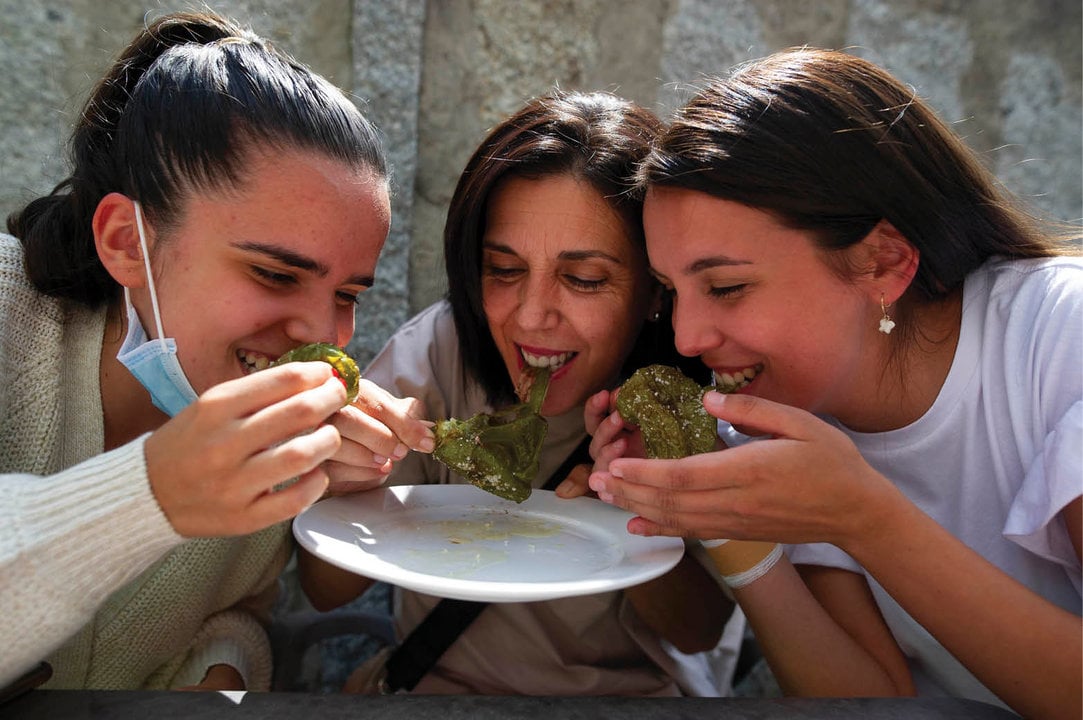 Tres mujeres degustando los pimientos en un bar de Arnoia.