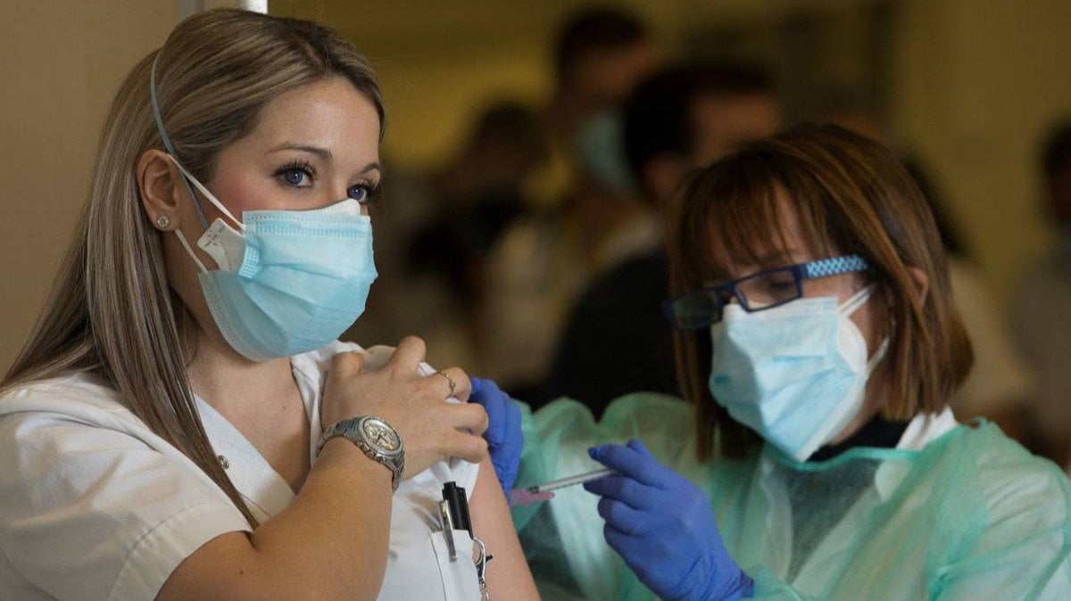  Una trabajadora sanitaria recibe la primera dosis de la vacuna contra el covid-19. 