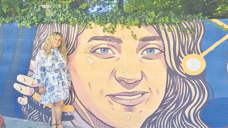 María Blanco junto a su mural