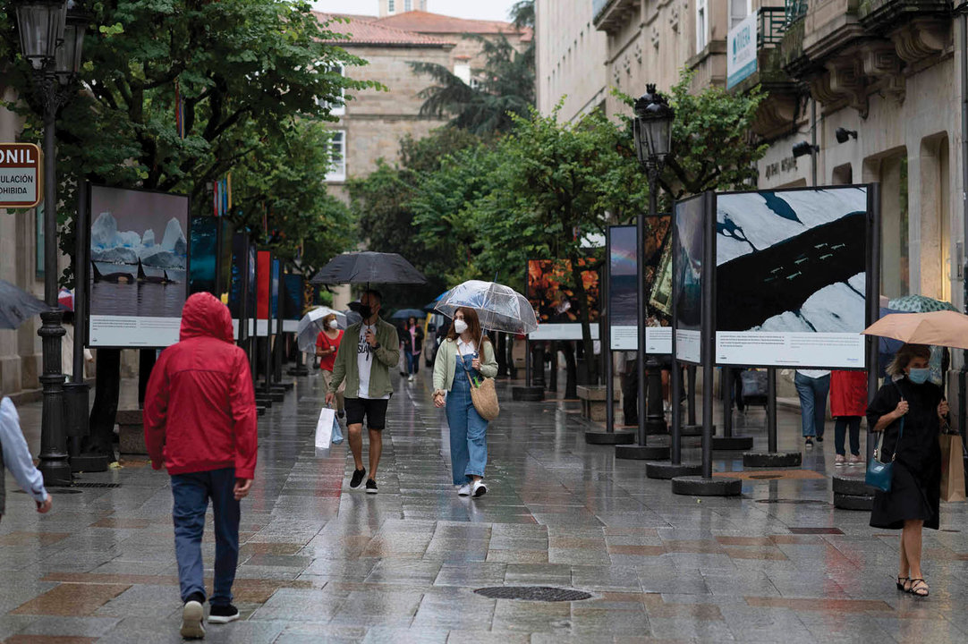 Varios viandantes paseaban ayer bajo la lluvia en la ciudad.
