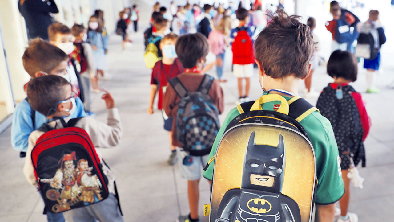 Niños, con sus mochilas al hombro, haciendo cola para entrar al colegio en el primer día de curso. JUAN HERRERO