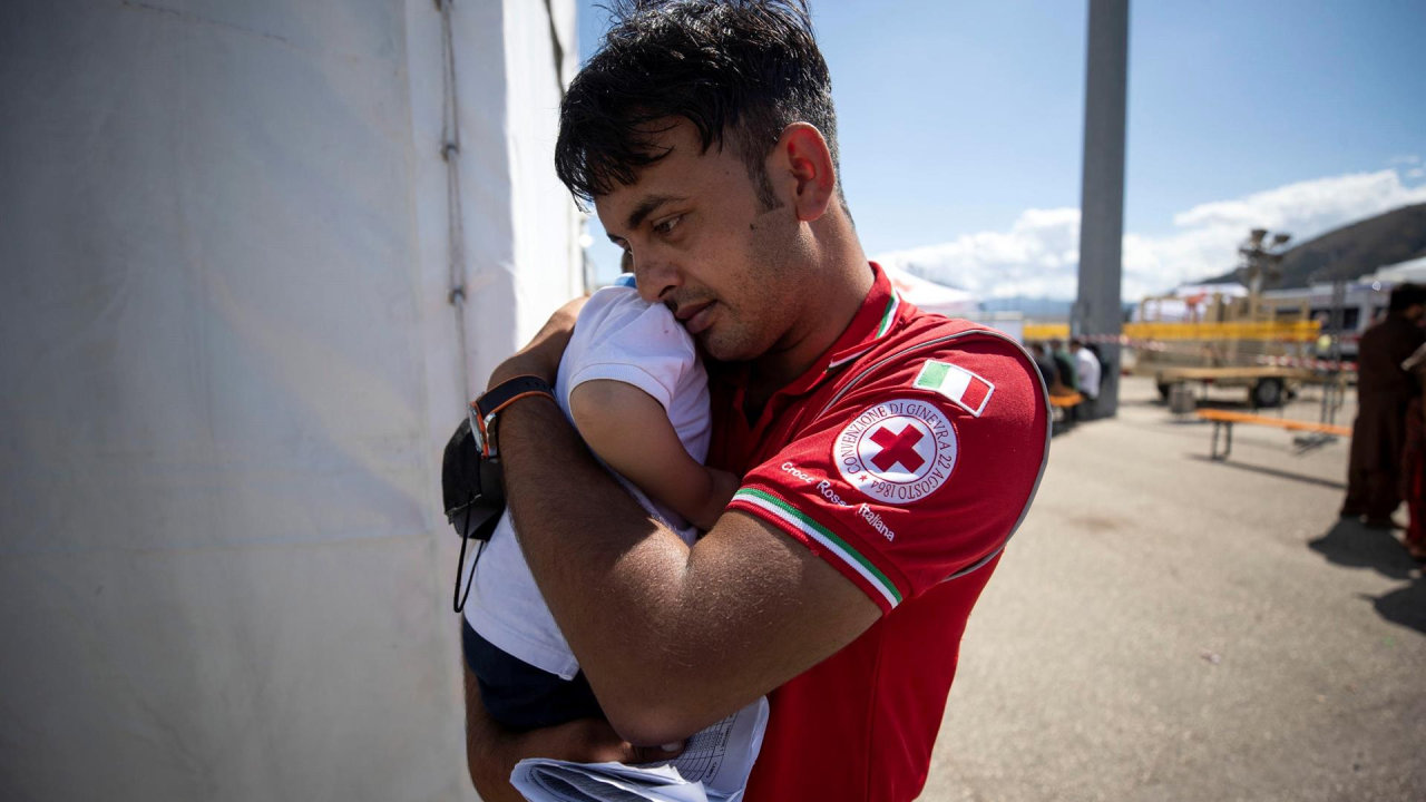 Un voluntario de la Cruz Roja sostiene a un niño recién llegado a Italia. MASSIMO PERCOSSI