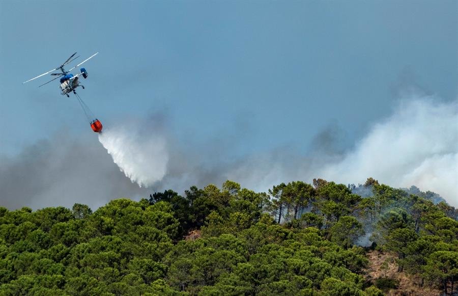 Uno de los helicópteros que participa en las labores de extinción del incendio en Málaga (EFE).