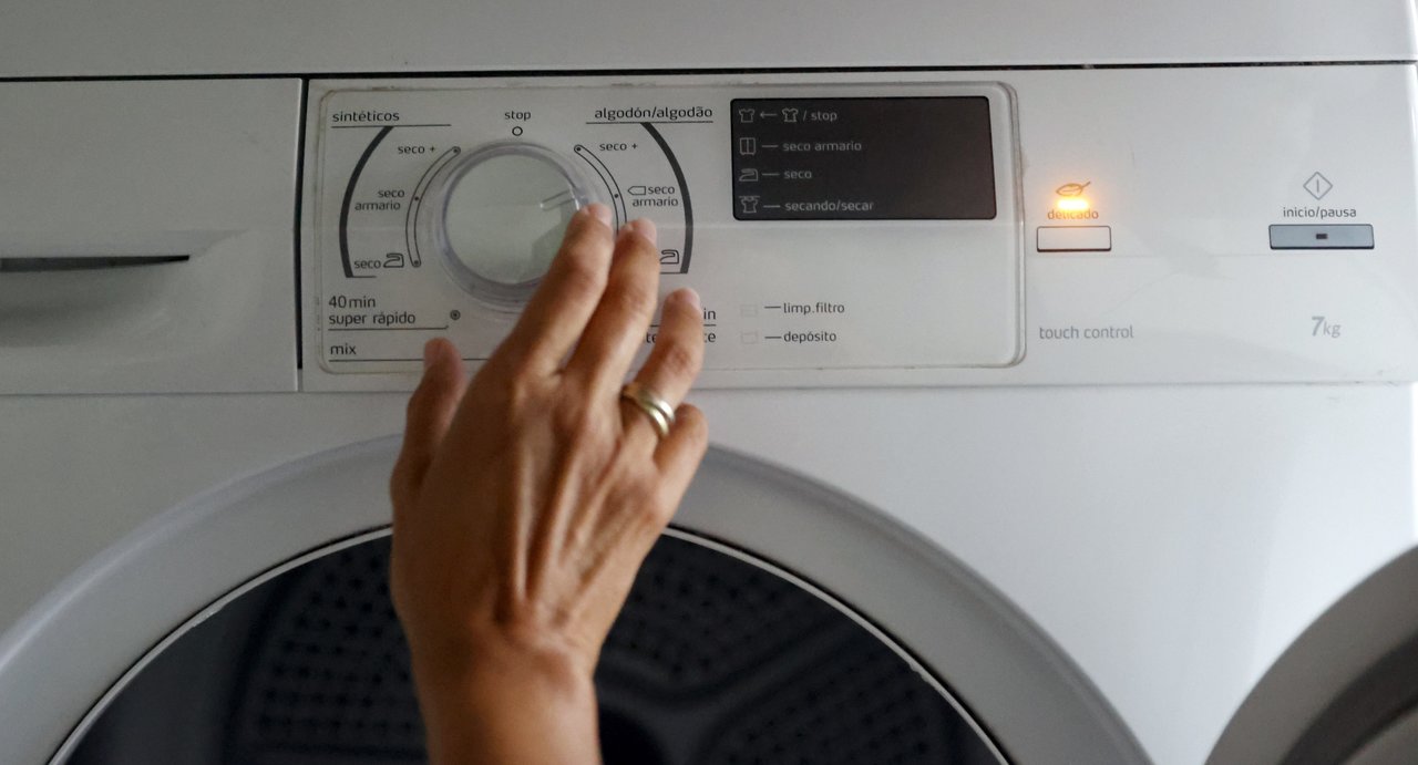  Una persona pone en funcionamiento una secadora de ropa. 