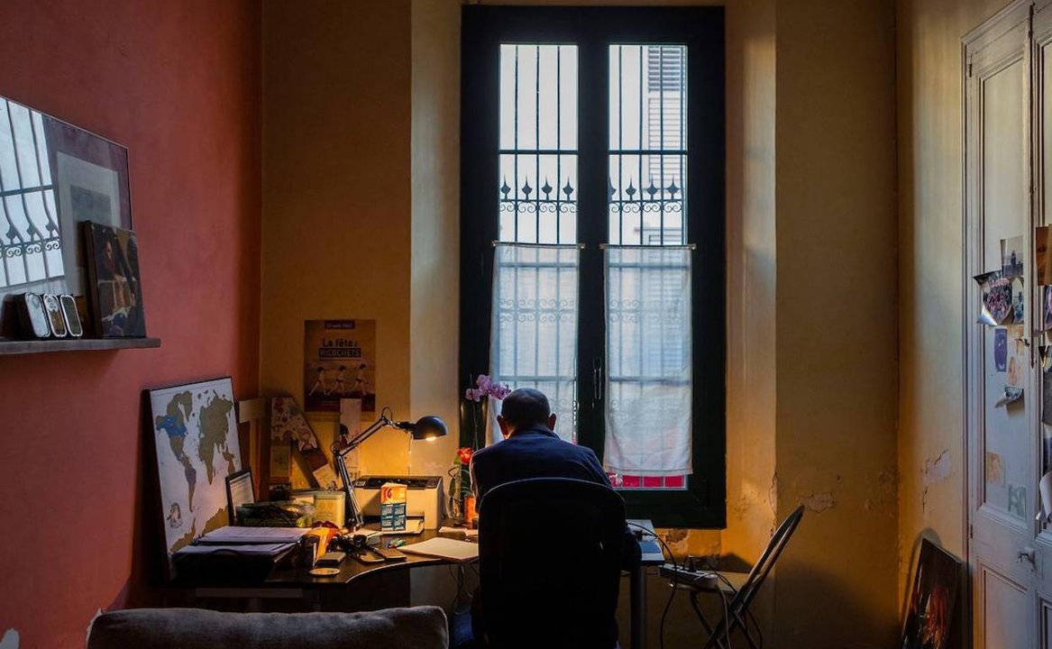  Un hombre realiza el trabajo a distancia con un ordenador desde su casa. 