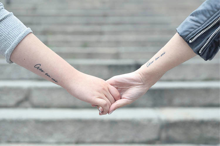 La joven agarrada de la mano de su hermana, con el mismo tatuaje que ella, para recordarle que no está sola (MARTIÑO PINAL).