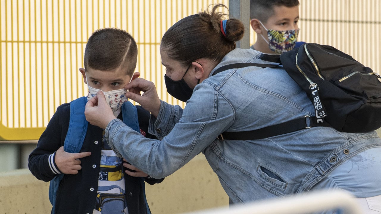 Una madre coloca la mascarilla a su hijo antes de entrar en un colegio de Ourense. (ÓSCAR PINAL)