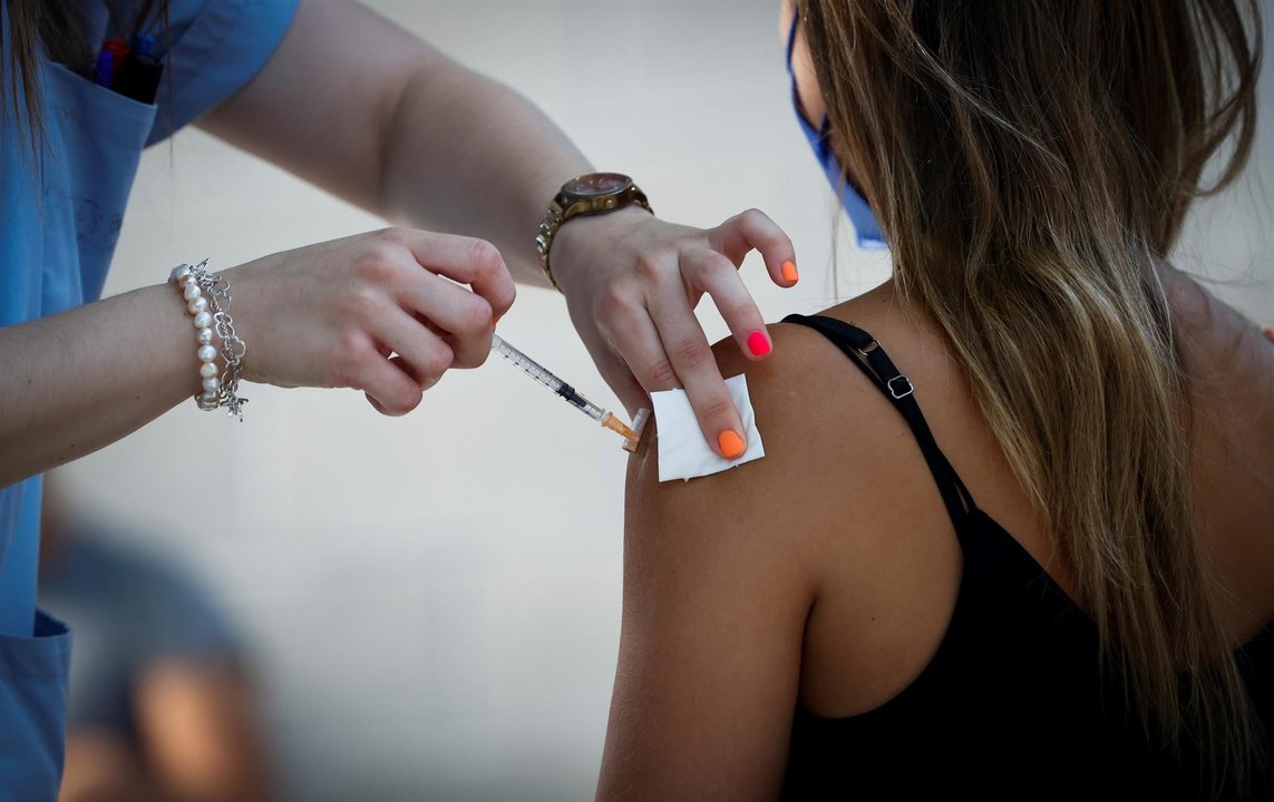 Una joven recibe la vacuna contra la covid.