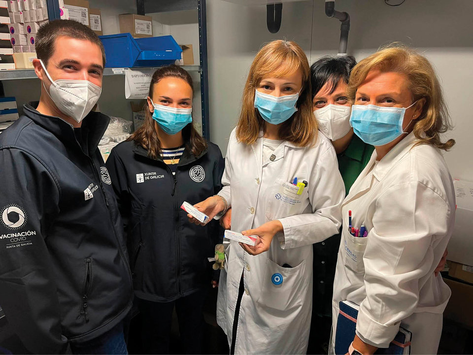 Enfermeros de la vacunación contra el covid muestran dos dosis del fármaco antigripal.