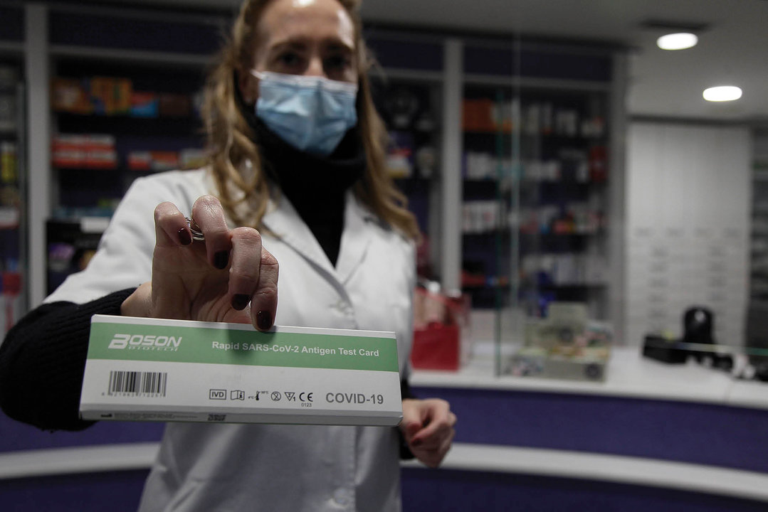 La dependienta de una farmacia ourensana posa con un test de antígenos.