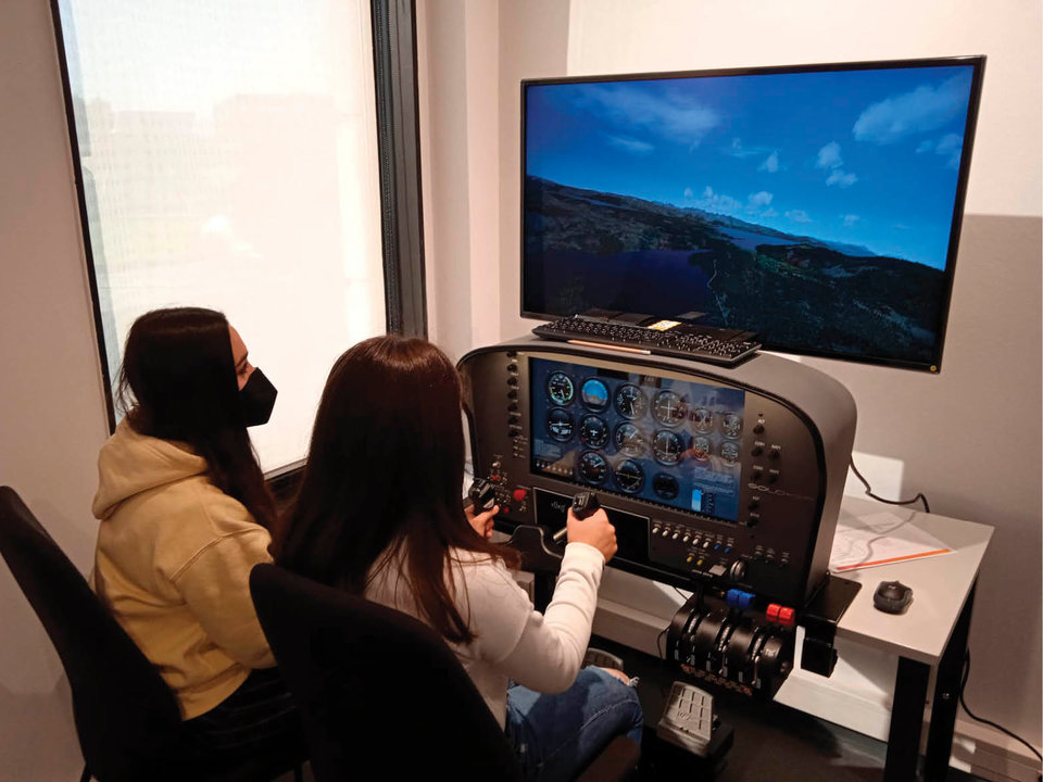 Dos alumnos realizando la simulación de vuelo en la Tecnopole.