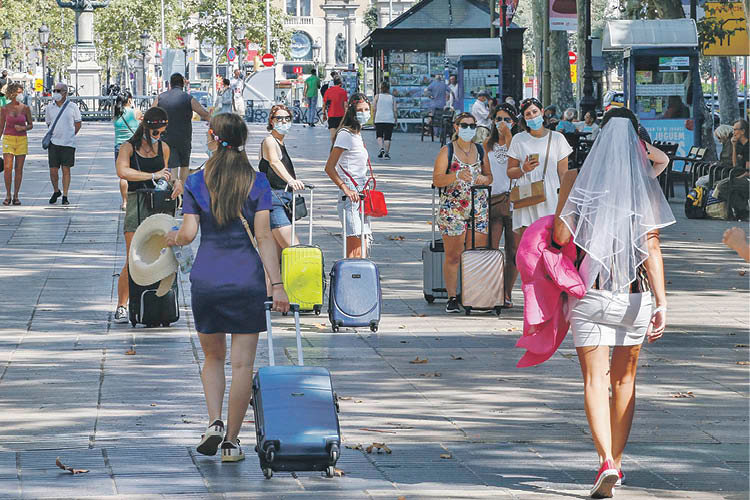 Una turista transita con su maleta por las Ramblas de Barcelona.