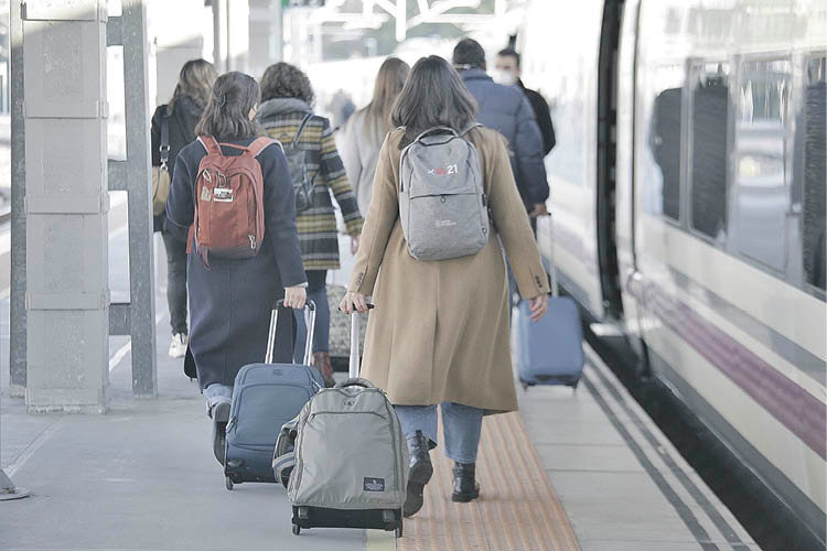 Viajeros en la estación de tren con sus maletas (MIGUEL ÁNGEL)