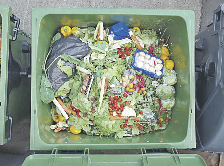 Un contenedor de basura repleto de restos de productos alimentarios.