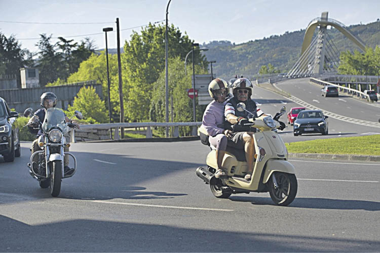 Tres personas circulan por Os Remedios en motocicleta.