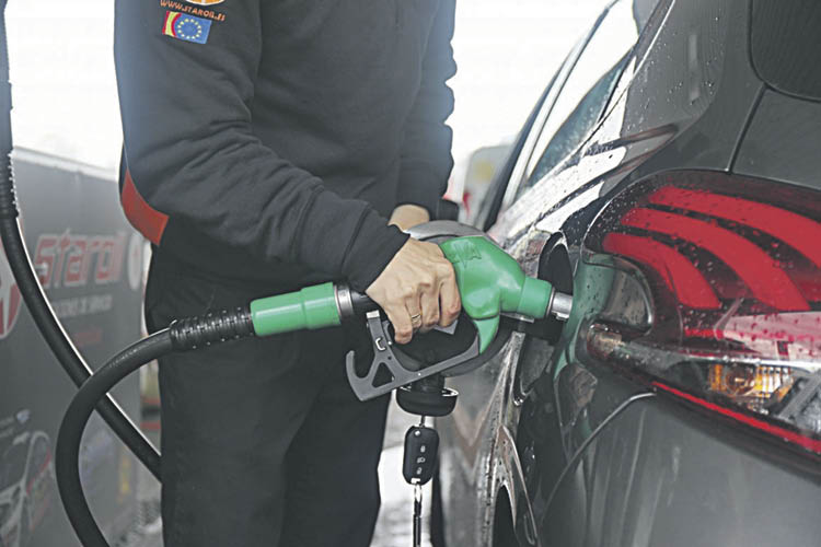 Un empleado de una estación de servicio echa carburante en un vehículo.