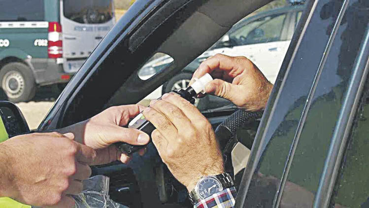 Un conductor introduce la boquilla en el alcoholímetro durante una prueba.