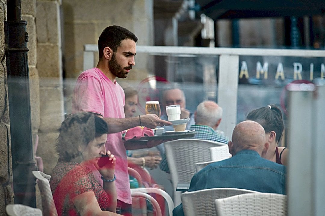 Un camarero sirve en una terraza de la Plaza Mayor de Ourense.