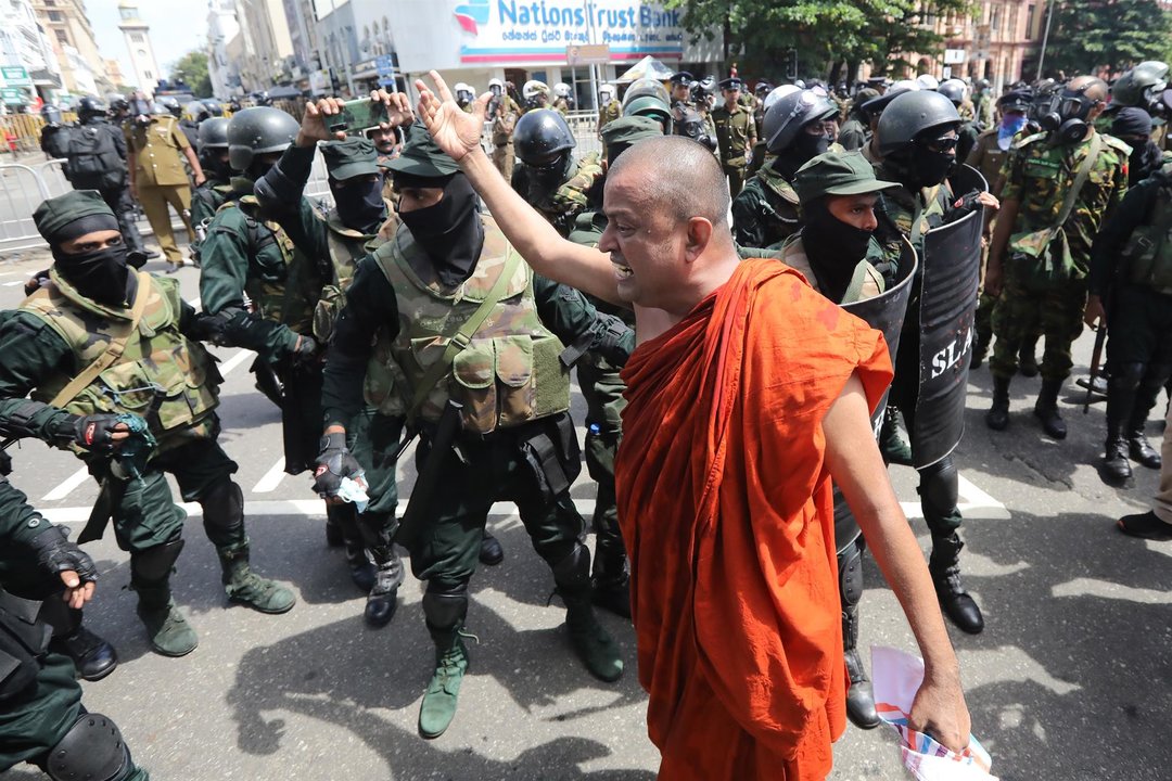 Un budista frente a la policía durante las protestas de Sri Lanka.