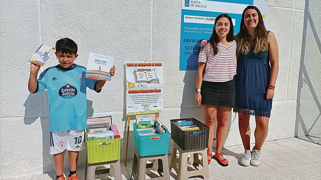 Alba Baltar y Raquel Souto, a la derecha, junto a Xabier Prol, que muestra los libros.