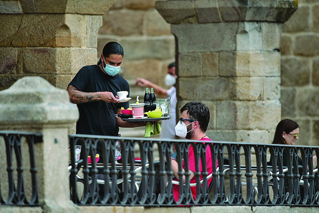 Un camarero sirve una terraza en Ourense. (OSCAR PINAL)