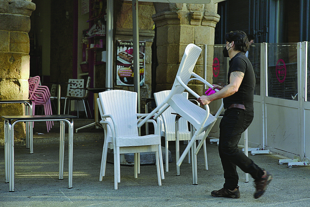 Un camarero de la ciudad coloca las sillas de su local. (MIGUEL ÁNGEL)