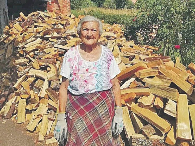 Pepa, vecina de Sande (Cartelle), de 87 años, posa con la leña que ha cortado.