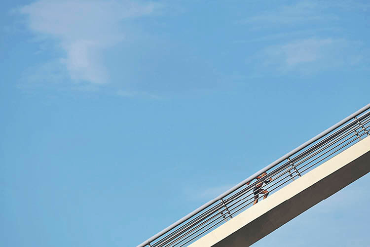 Un hombre asciende por las escaleras del puente del Milenio, ayer por la tarde. ÓSCAR PINAL