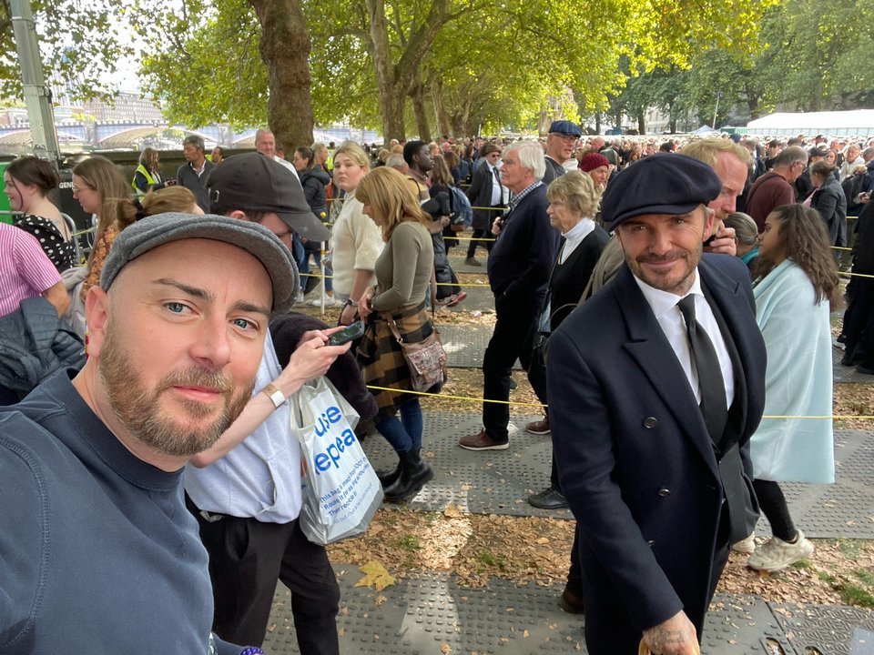Beckham, a la derecha, se hace un selfi con un seguir en la cola para acceder a la capilla ardiente de Isabel II. // @MrChrisAnstee