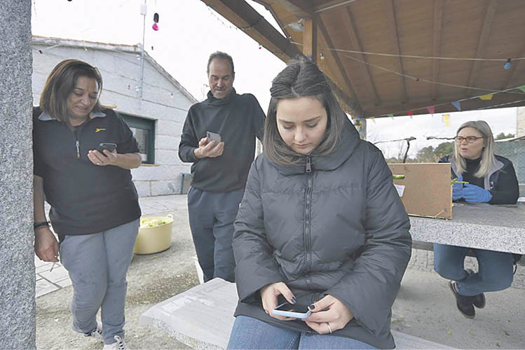 Un grupo de vecinos de Trellerma (Toén) disfrutra de wifi gratis en las plazas. XESÚS FARIÑAS