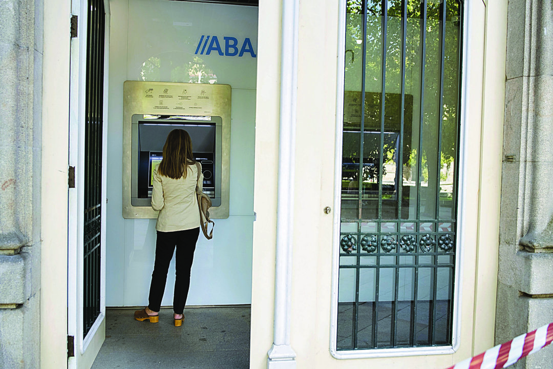 Una clienta hace una operación bancaria en un cajero de Abanca. (XESÚS FARIÑAS)