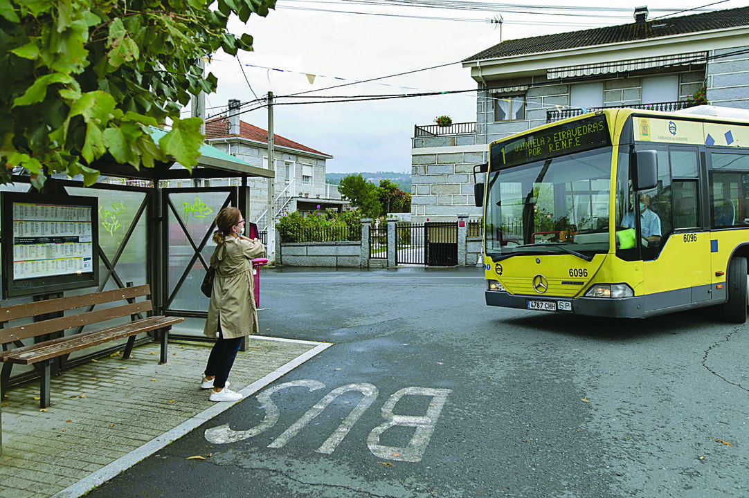 Una mujer espera el autobús en el centro de Seixalbo, una de las zonas afectadas.  (MARTIÑO PINAL)