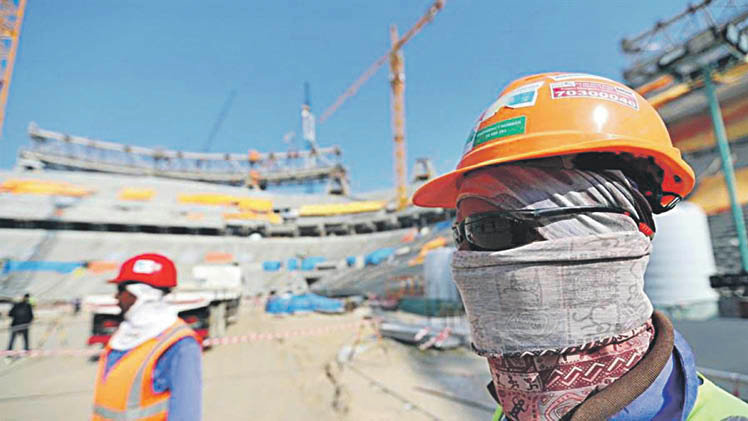 Trabajadores protegidos contra el sol en la construcción de los estadios de Qatar.