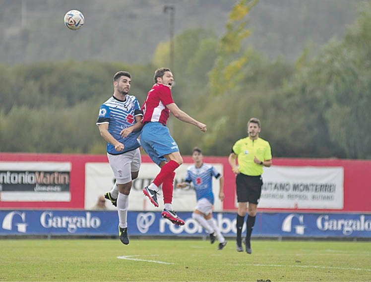 El delantero del Verín Hugo García salta en la disputa de un balón en el campo José Arjiz.