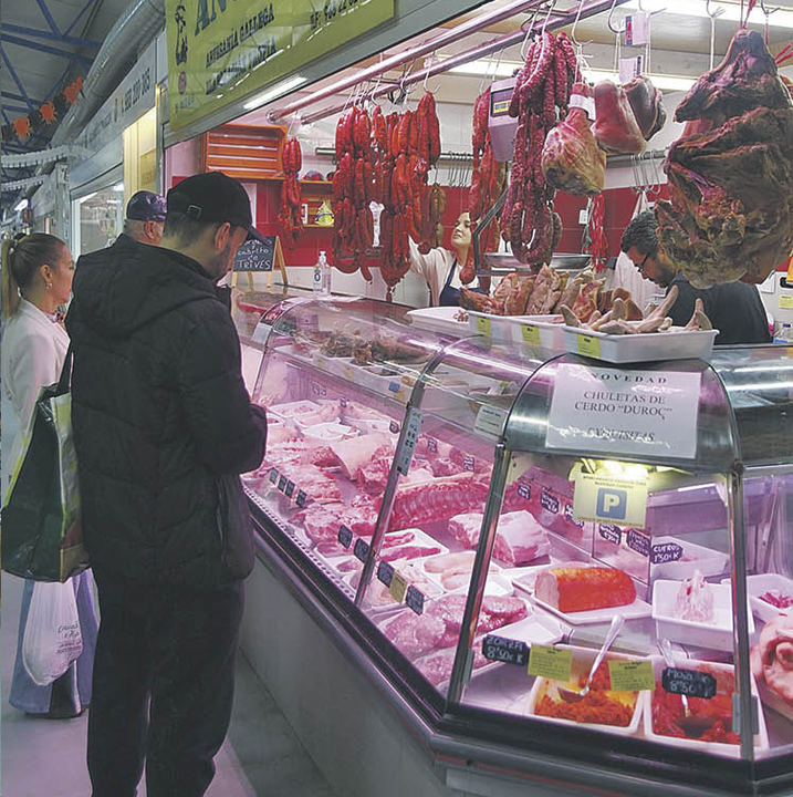 Clientes, comprando carne en un puesto del Mercado de Abastos de Ourense.