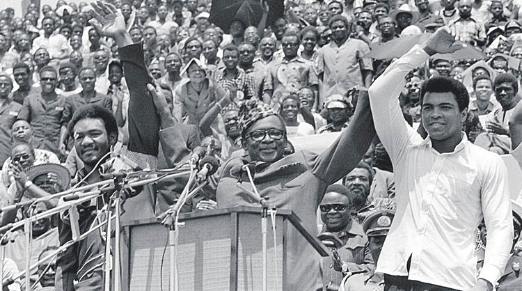 Mobutu alza los brazos de Foreman y Ali durante la presentación pública del combate.