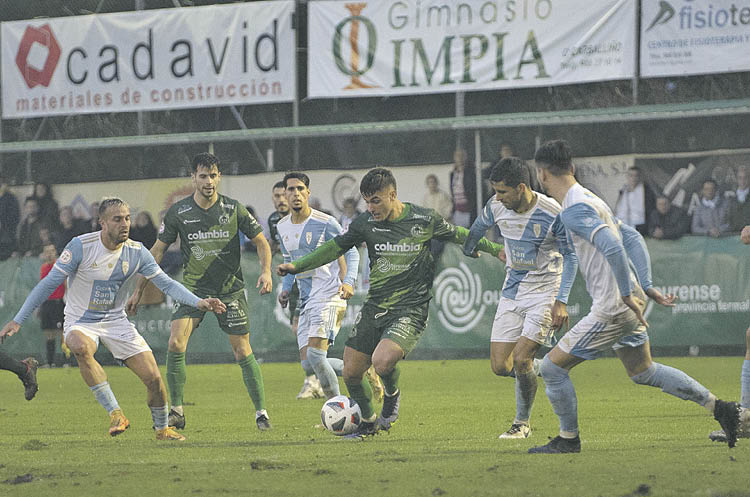 El futbolista del Arenteiro Antón Escobar controla la bola rodeado de jugadores del Compostela.