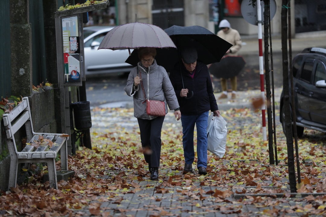 Dos personas caminan por la ciudad bajo la lluvia. (José Paz)