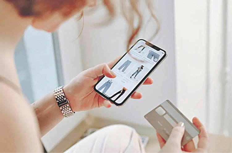 Una consumidora compra ropa “online” con la tarjeta bancaria.