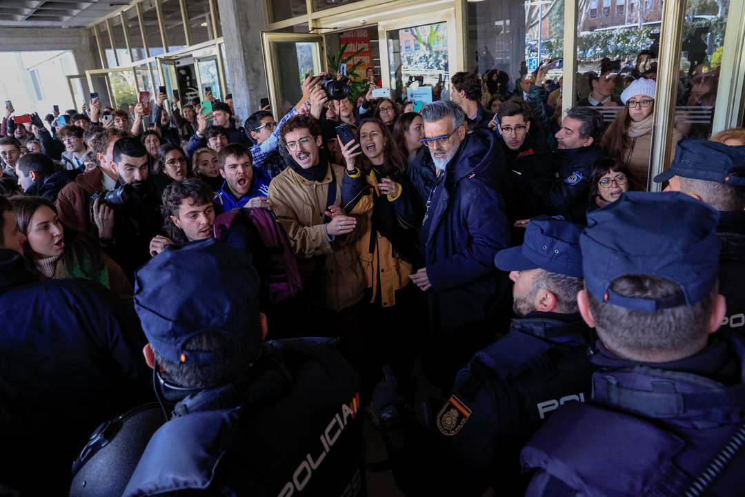 Agentes de la Policía ante los estudiantes que protestan a las puertas de la facultad de Ciencias de la Información en la Complutense de Madrid. Foto: EFE.