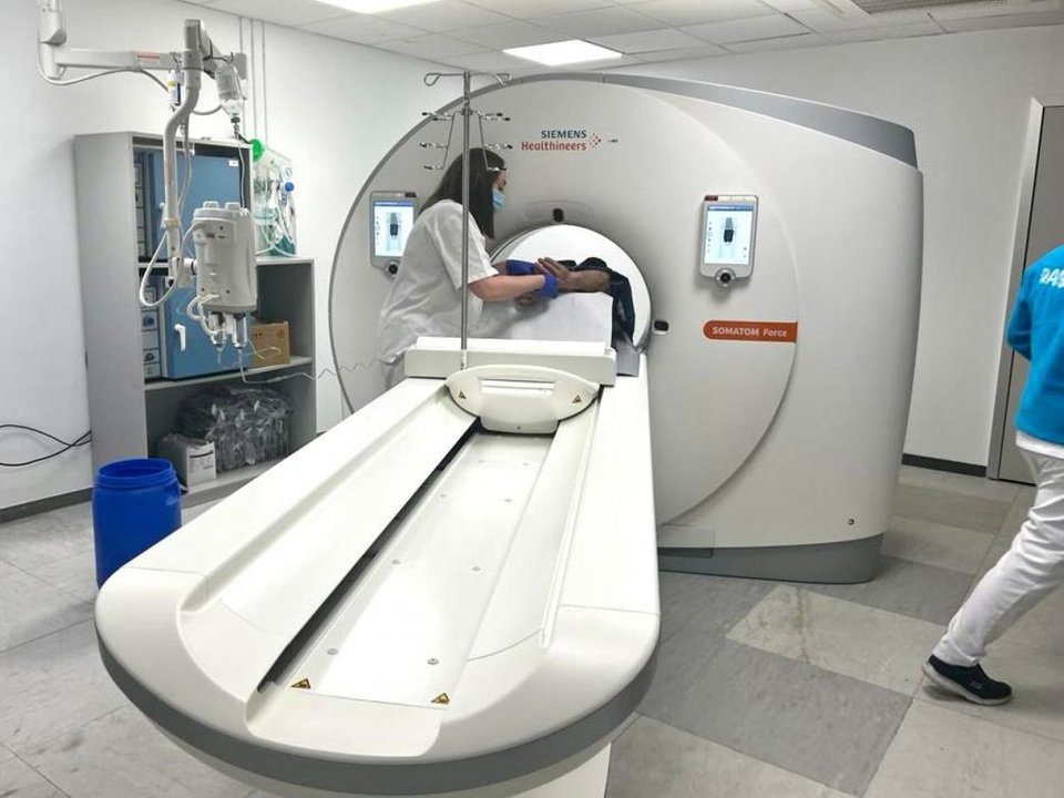 Una sanitaria coloca al paciente en el interior del tomógrafo.