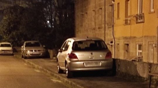 Coche aparcado en la acera en Ourense.