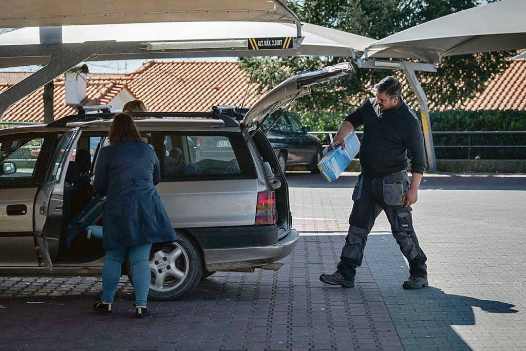 Vecinos portugueses cargan su coche tras realizar unas compras en Chaves. ÓSCAR PINAL