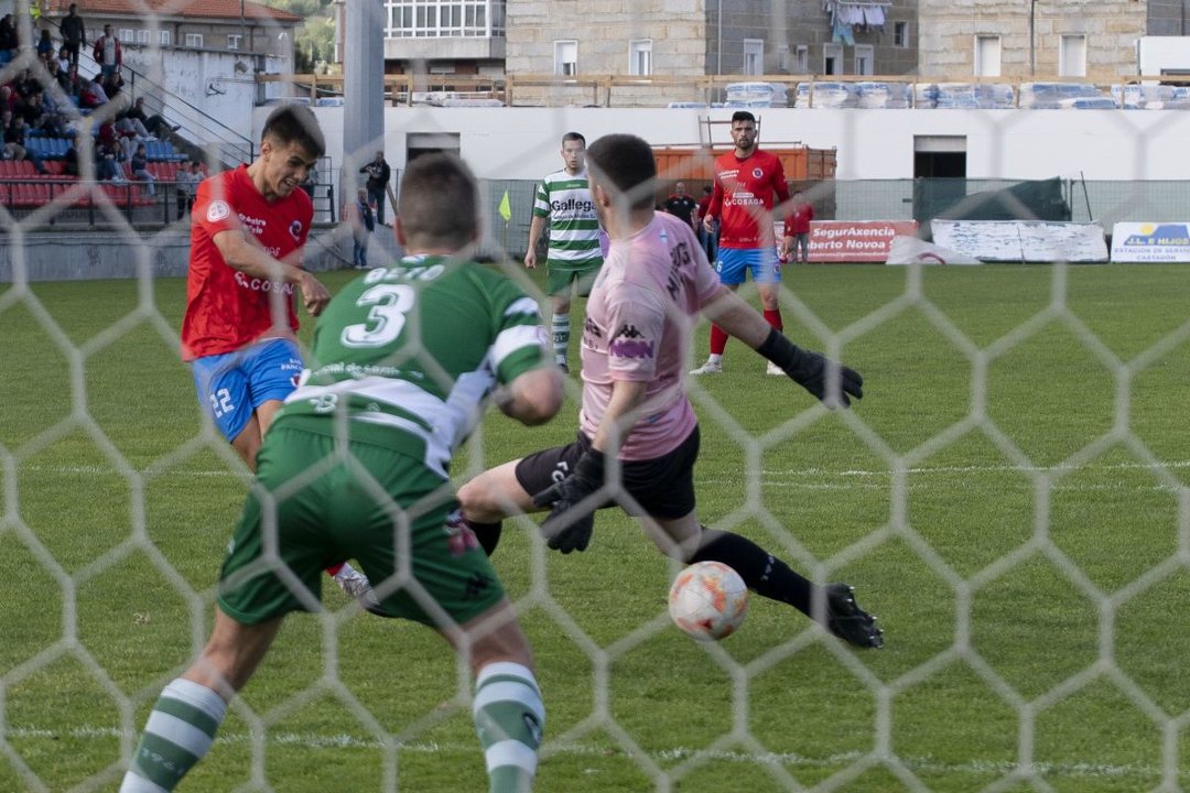 El rojillo Osián lanza para marcar el primer gol del partido en O Couto (Foto: Martiño Pinal).
