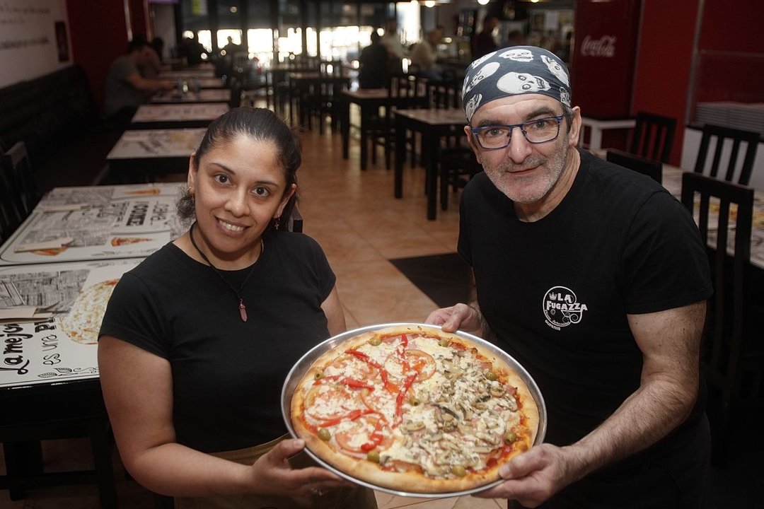 Laura y Fabio con una suculenta pizza lista para ser servida en La Fugazza.