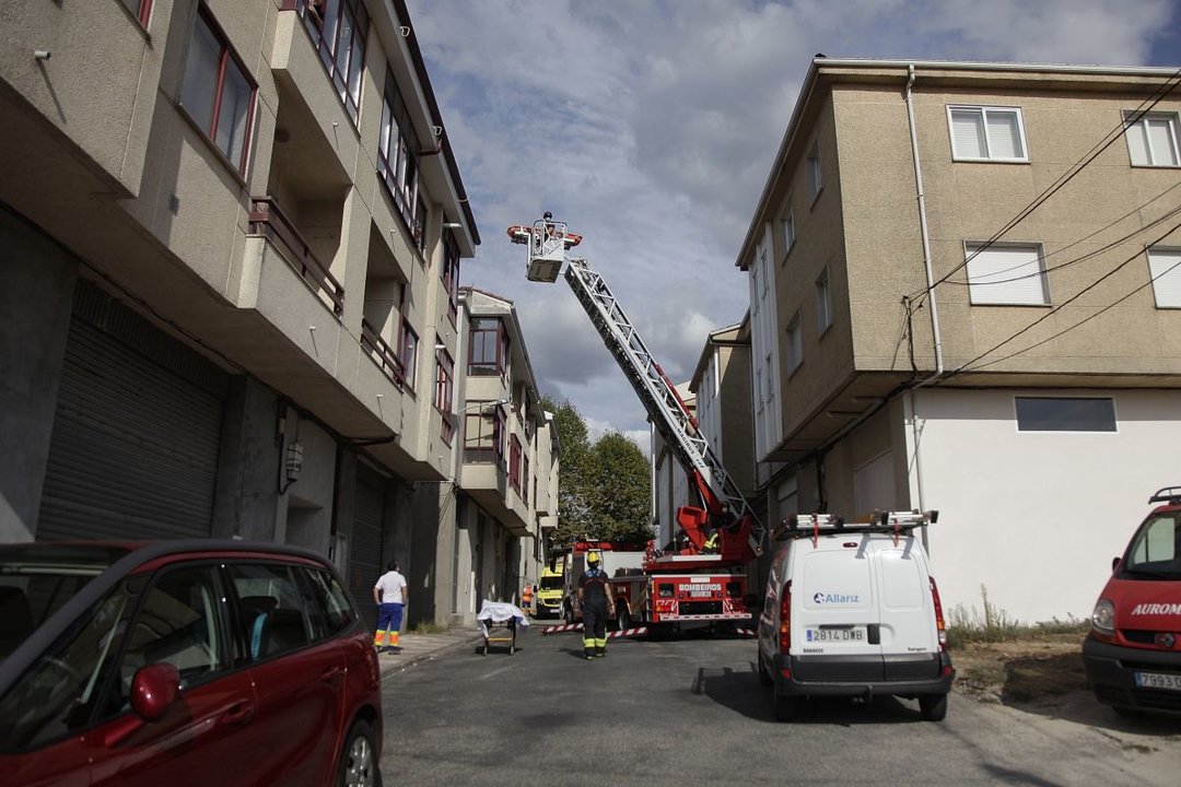 Los bomberos de Ourense auxiliando a una persona mayor en su casa.