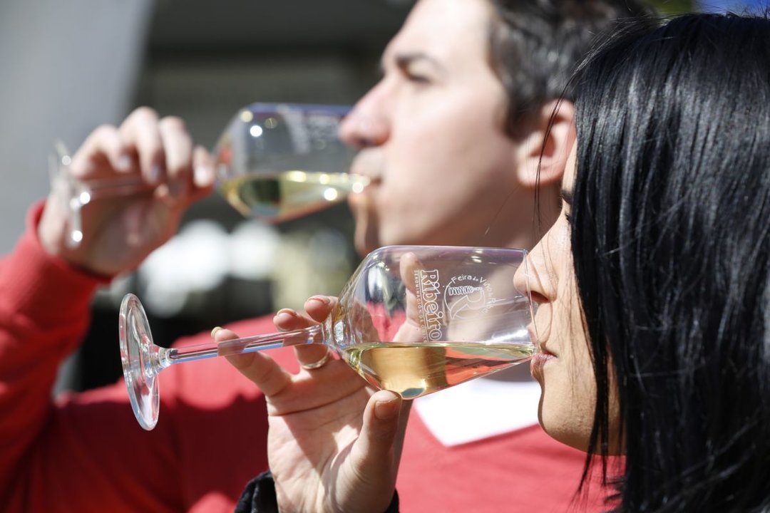 Un hombre y una mujer degustan sendos vinos del Ribeiro.