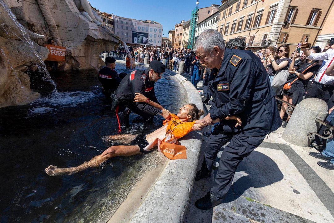 Activistas detenidos por la policía italiana tras teñir de negro el agua de la Fuente de los Cuatro Ríos en Roma. (FOTO:EFE).