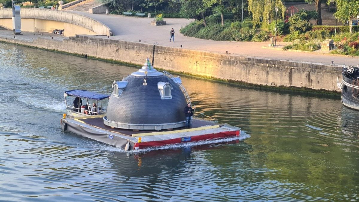 Una de las cúpulas es transportada sobre las aguas del Sena, en París.