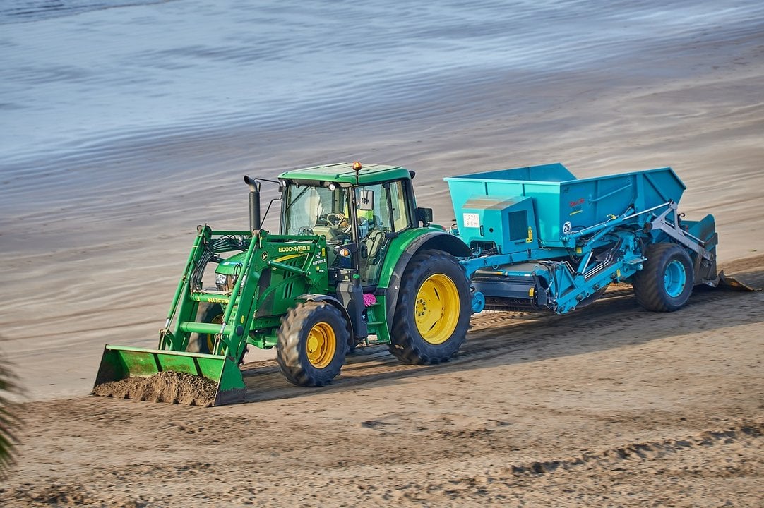 Un tractor con cribador limpia una playa. (FOTO: PIXABAY).